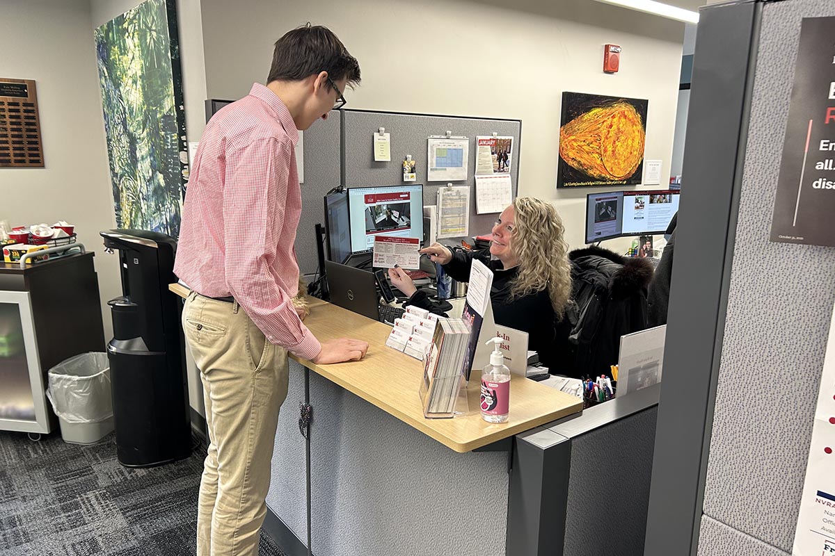 A faculty member being waited on in the Disability Services lobby