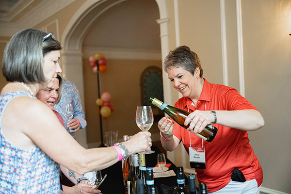 a woman pouring wine into a glass