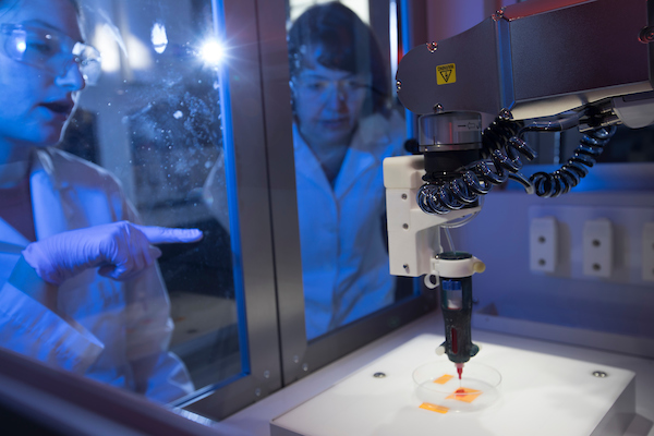 Professor Sparks in the lab with a student using the 3D printer